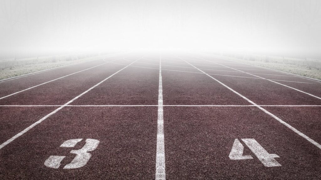 A foggy track field with visible lane numbers and white lines.